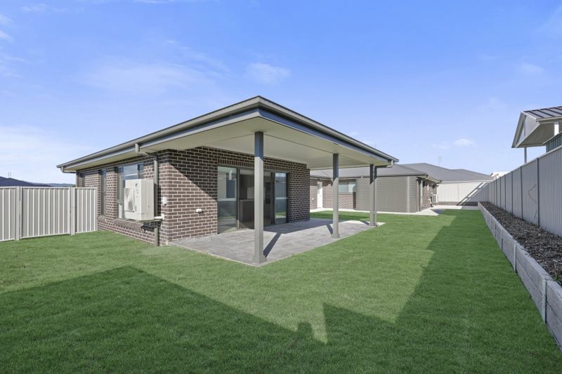 Covered rear patio opening onto a level lawn.