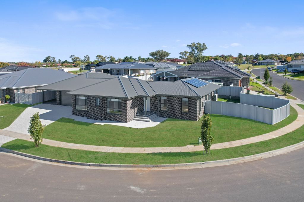Aerial view of Hillvue House at 38 Mustang Close: a single-storey brick home on a landscaped corner block with a curved footpath and lawn.